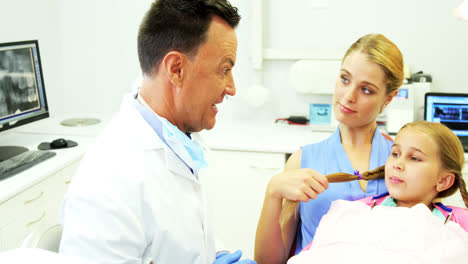 Dentist-showing-young-patient-how-to-brush-teeth