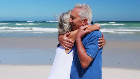 Senior-couple-hugging-each-other-at-the-beach