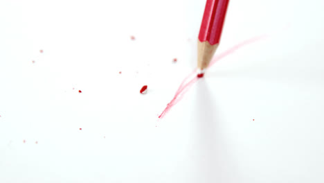 Red-colored-pencil-with-broken-tip-with-notebook