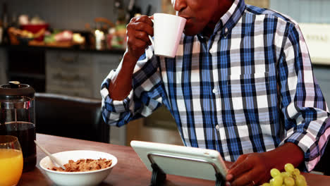 Lächelnder-älterer-Mann-Mit-Digitalem-Tablet-Beim-Frühstück