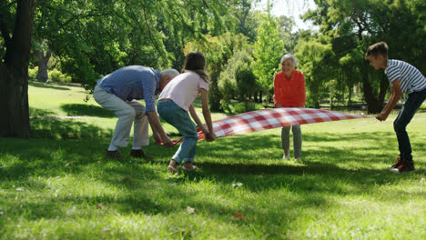 Multi-generation-family-placing-blanket-in-the-park