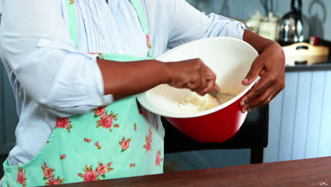 Senior-woman-mixing-flour-in-a-bowl