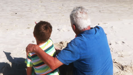 Grandfather-and-grandson-interacting-with-each-other-at-the-beach