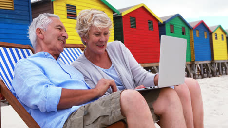 Älteres-Paar-Mit-Laptop-Am-Strand