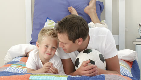 Vater-Und-Sohn-Schauen-Sich-Im-Schlafzimmer-Ein-Fußballspiel-An