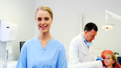 Smiling-dental-assistant-standing-in-dental-clinic