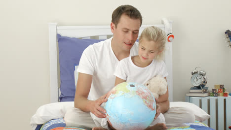 Father-and-daughter-looking-at-a-terrestrial-globe