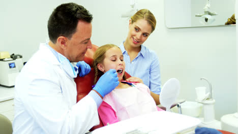 Dentist-examining-a-young-patient-with-a-tool