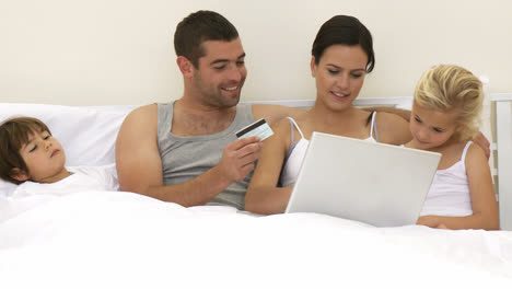 Family-in-bed-buying-online