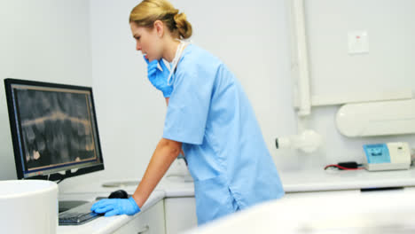Female-nurse-examining-x-ray-report-on-computer