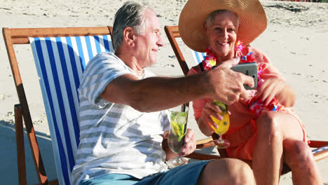 Senior-couple-taking-selfie-on-mobile-phone-while-having-cocktail