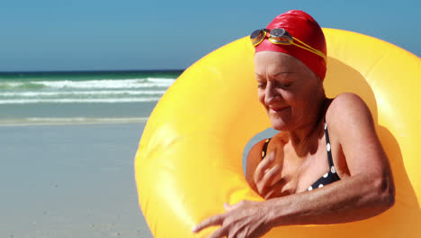 Ältere-Frau-Mit-Schwimmring-Am-Strand