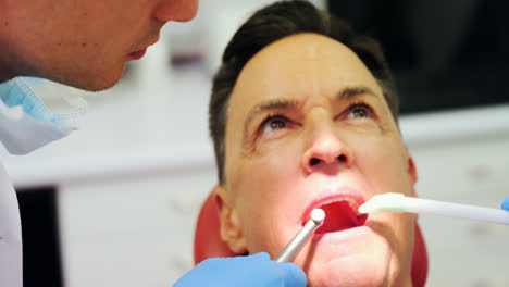 Dentistas-Examinando-A-Un-Paciente-Masculino-Con-Herramientas