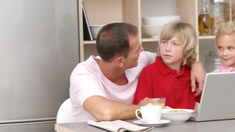 Panorama-Von-Eltern-Und-Kindern-Beim-Frühstück-Und-Mit-Einem-Laptop-In-Der-Küche