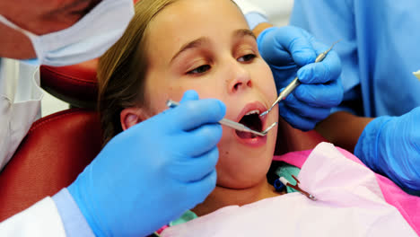 Mittelteil-Eines-Zahnarztes-Und-Einer-Krankenschwester,-Die-Einen-Jungen-Patienten-Mit-Werkzeugen-Untersuchen