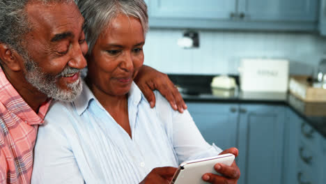 Senior-couple-using-digital-tablet-in-kitchen