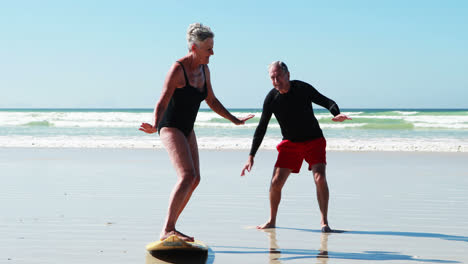 Senior-man-training-woman-on-beach-