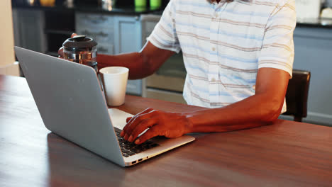 Senior-man-using-laptop-while-having-coffee