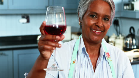 Ältere-Frau-Trinkt-Wein-In-Der-Küche