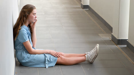 Schoolgirl-talking-on-mobile-phone-in-corridor