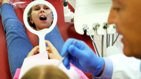 Dentista-Examinando-A-Un-Paciente-Joven-Con-Una-Herramienta