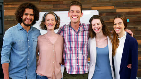 Portrait-of-happy-business-team-standing-with-arms-around