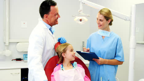 Dentist-interacting-with-female-dental-assistant