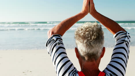 Ältere-Frau-Macht-Yoga-Am-Strand