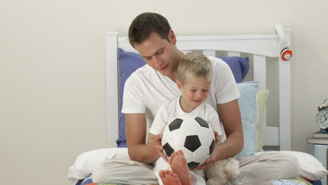 Vater-Und-Sohn-Spielen-Mit-Einem-Fußball-Im-Schlafzimmer