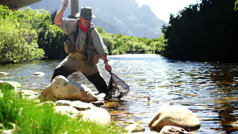 Fly-fisherman-catching-trout-in-fishing-net