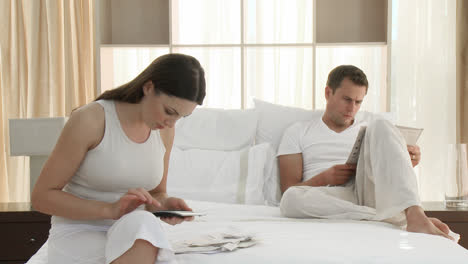 Woman-checking-bills-in-the-bedroom