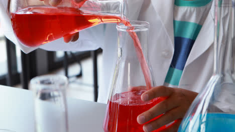 Attentive-schoolboy-doing-a-chemical-experiment-in-laboratory