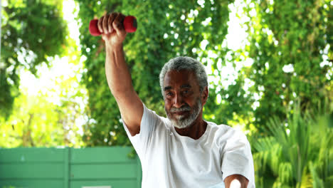 Senior-man-exercising-with-dumbbell-at-home