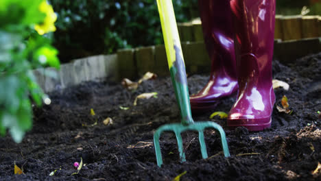 Senior-woman-digging-with-garden-fork
