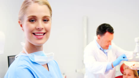 Smiling-dental-assistant-standing-in-dental-clinic