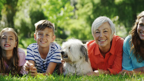 Multi-generation-family-relaxing-with-their-dog-in-the-park