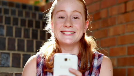 Happy-schoolgirl-using-mobile-phone