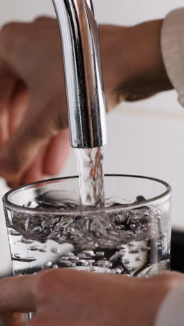 Person-filling-glass-with-water