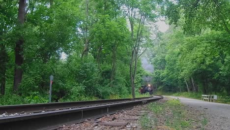 A-View-of-a-Tank-Engine-Approaching-Around-a-Curve,-Pulling-Passenger-Coaches-on-a-Summer-Day