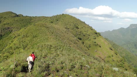 Un-Hombre-Tribal-Guía-A-Un-Turista-Por-Un-Sendero-De-Montaña-En-Uganda
