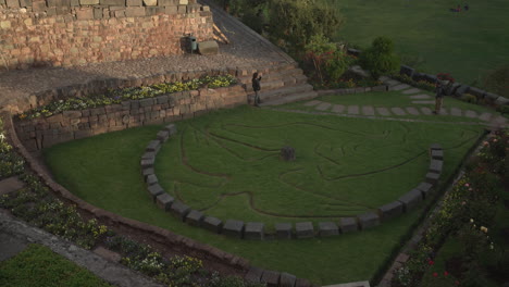 Solar-Garden,-located-within-Qorikancha-in-Cusco-Peru-served-as-repository-for-offerings-representing-flora-and-fauna,-a-traveler-admiring-its-beauty