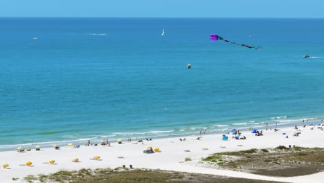 Wunderschöne-Strandszene-In-Florida-Mit-Strandbesuchern-Vor-Den-Wellen-Des-Golfs-Und-Booten