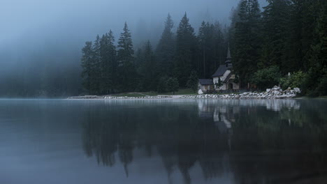 Lake-church-in-Dolomite-mountains-on-foggy-day,-time-lapse-view