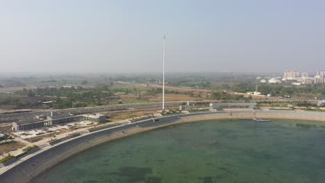 rajkot-atal-lake-drone-view-Many-roads-are-going-behind-it-and-a-big-field-is-also-visible,-Rajkot-New-Race-Course,-Atal-Sarovar