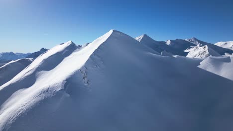 a-drone-flies-around-a-big-snow-covered-mountain-in-the-alps