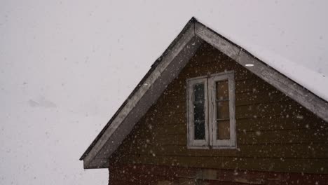 Snowflakes-Gently-Float-by-the-Attic-Window-in-Gulmarg,-Kashmir,-India---Medium-Shot
