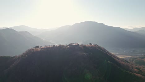 Ancient-Japanese-Takeda-Castle-Ruins-Landscape-in-Sunshine-Summit-Mountain-Range-Aerial-Drone-Panoramic-View