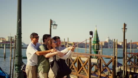 Eine-Touristenfamilie-Aus-Asien-Macht-Ein-Selfie-Mit-Einem-Selfie-Stick-Auf-Dem-Berühmten-Markusplatz-In-Venedig