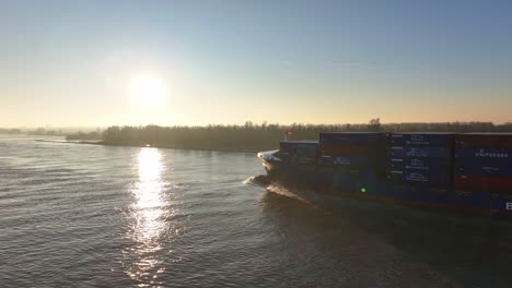 Luftaufnahme-Eines-Frachtschiffs-Der-BG-Freight-Line,-Das-Bei-Sonnenaufgang-über-Einem-Fluss-Segelt