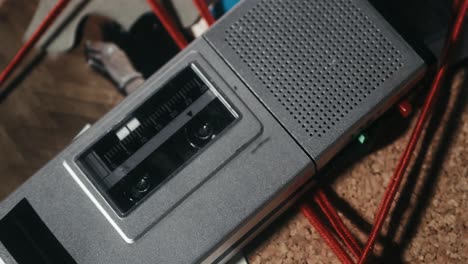The-cassette-recorder-is-lying-on-the-investigation-board,-with-the-evidence-connected-by-a-red-string